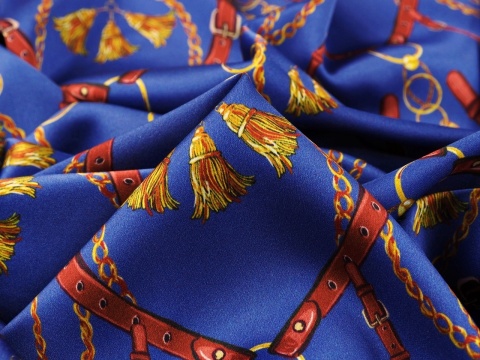 niebieski jedwab w złote łańcuszki, chwosty i brązowe uzdy