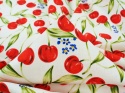 biała tkanina w czerwone wisienki i drobne, niebieskie niezapominajki