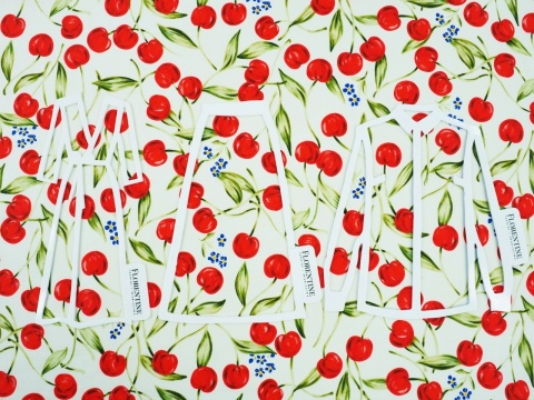 biała tkanina w czerwone wisienki i drobne, niebieskie niezapominajki