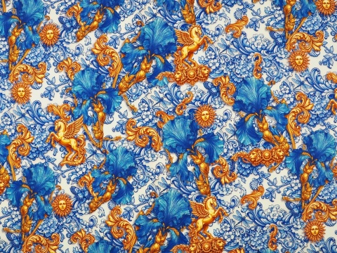 jedwab w niebieskie irysy i ornamenty raz złote słońca i pegazy na bialym tle