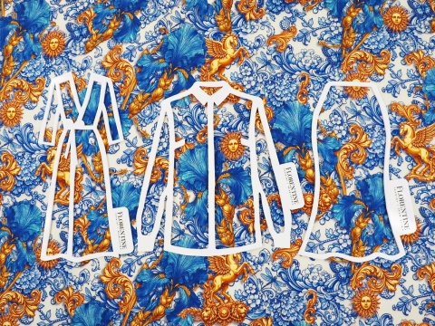 jedwab w niebieskie irysy i ornamenty raz złote słońca i pegazy na bialym tle