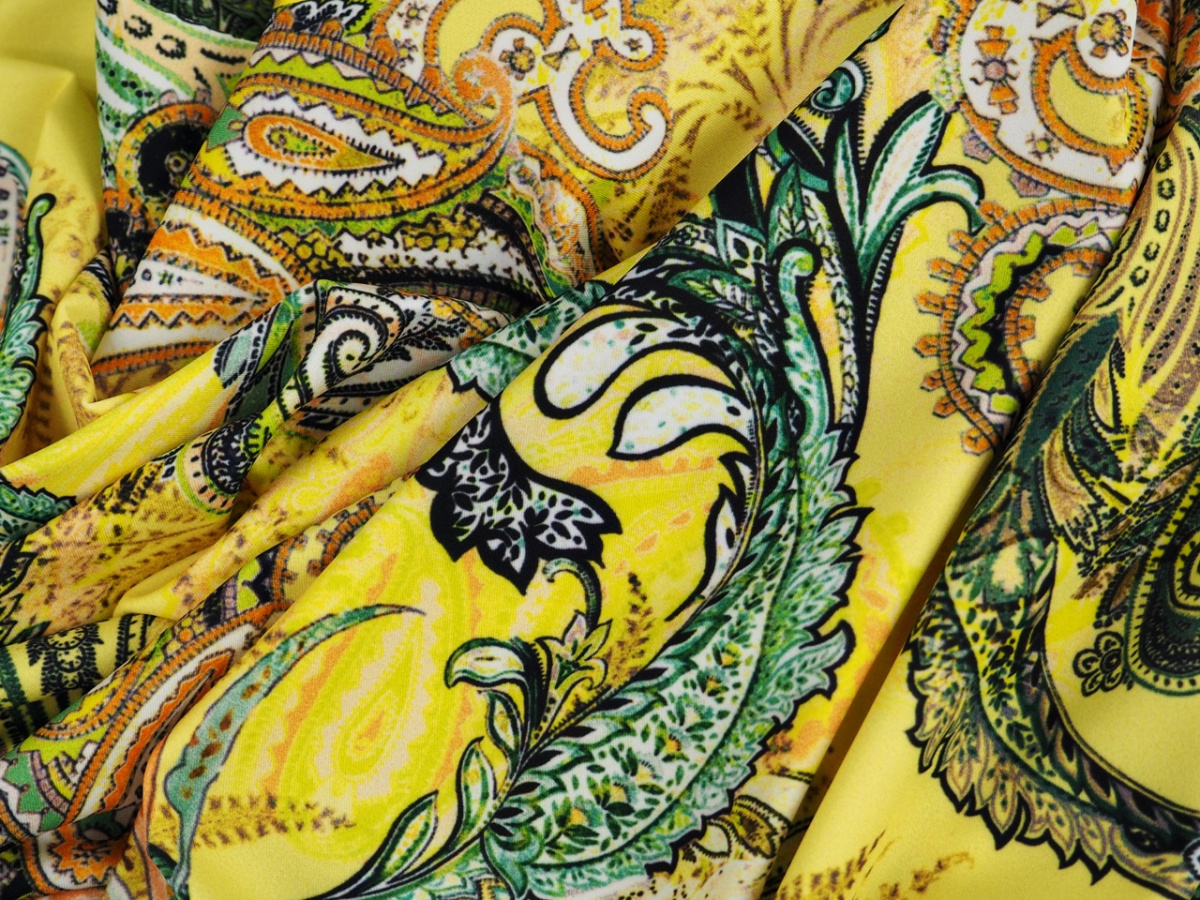 Lycra dzianina - Kolorowe paisley na kanarkowym tle Lycra dzianina - Kolorowe paisley na kanarkowym tle