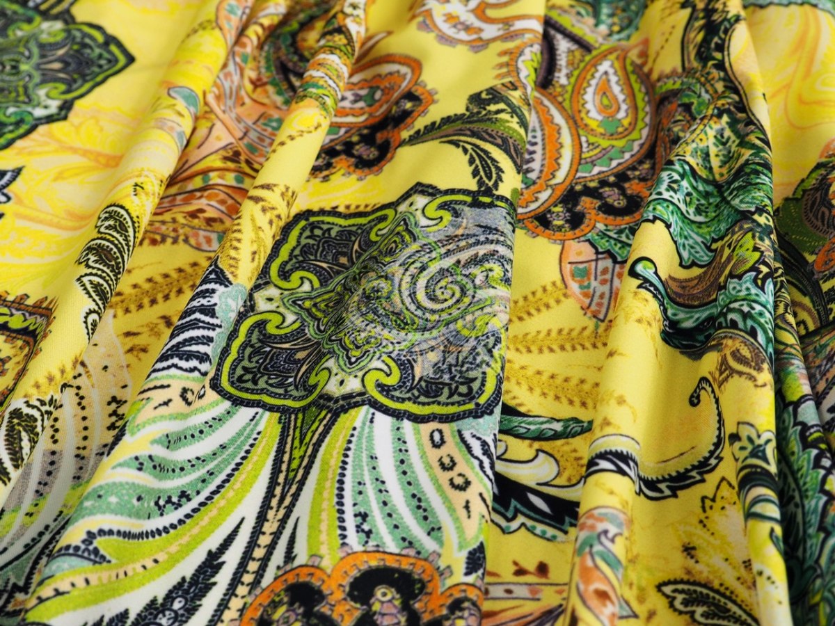 Lycra dzianina - Kolorowe paisley na kanarkowym tle Lycra dzianina - Kolorowe paisley na kanarkowym tle