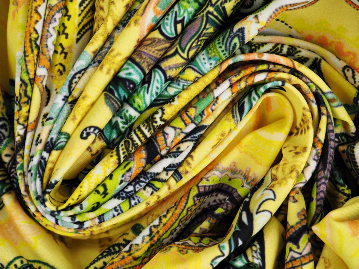 Lycra dzianina - Kolorowe paisley na kanarkowym tle Lycra dzianina - Kolorowe paisley na kanarkowym tle